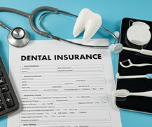 Dental insurance form next to dental instruments