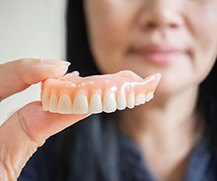 a person holding a set of full dentures