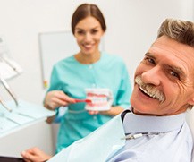 a patient smiling while wearing his new dentures