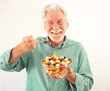 Man eating fruit with dental implants