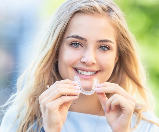 Hand holding an Invisalign tray