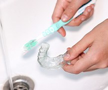 Patient in Ellicott City cleaning their Invisalign tray