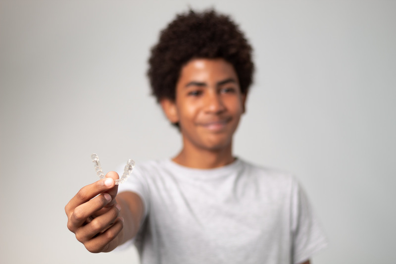 Patient smiling with their Invisalign aligners