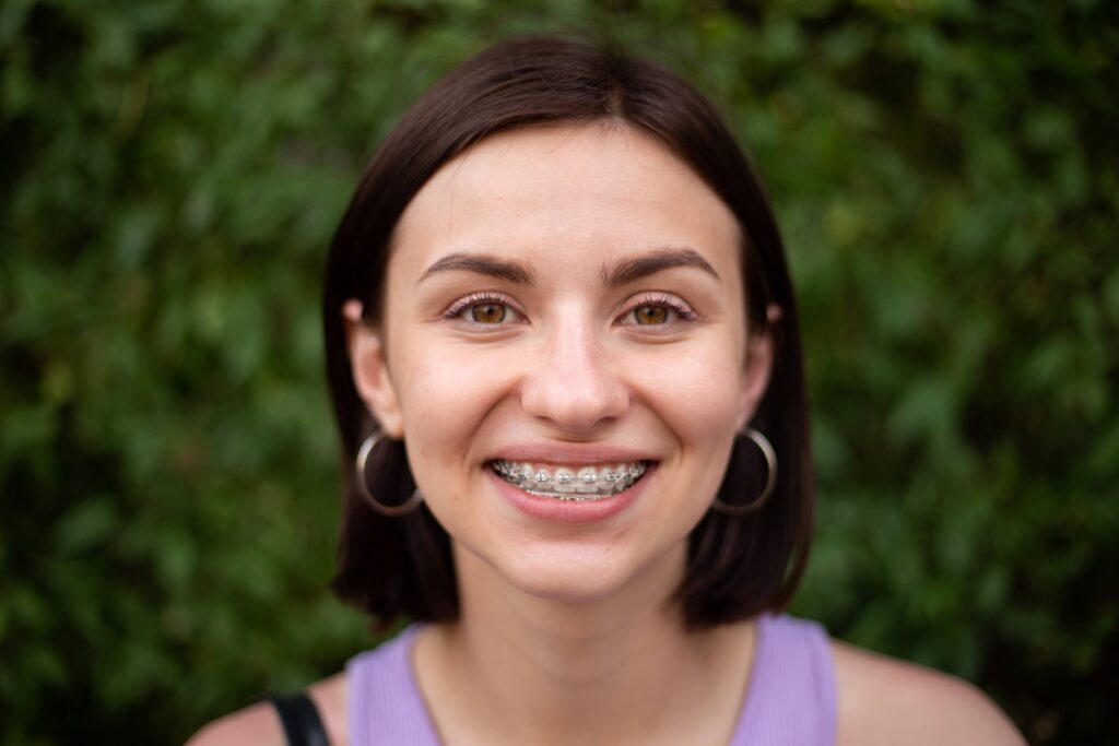 Woman with traditional braces smiling